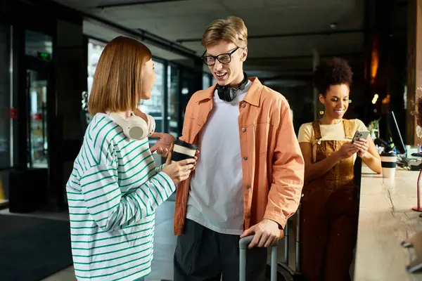 Два коллеги ведут беседу, в то время как один наслаждается кофе в оживленной обстановке отеля. — стоковое фото