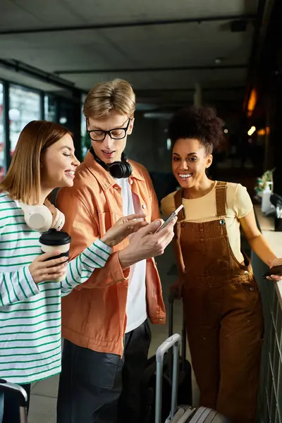 Three colleagues engage and share laughter while reviewing travel plans in a hotel setting. — Stock Photo
