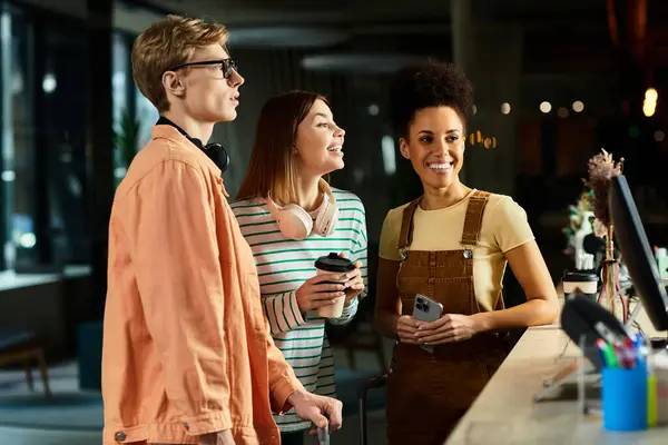 Tre colleghi condividono un momento di luce nella hall dell'hotel mentre discutono i loro piani di viaggio. — Foto stock