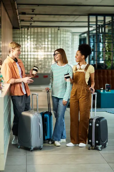 Colleghi impegnarsi in una conversazione amichevole durante l'attesa nella hall dell'hotel, tenendo tazze di caffè. — Foto stock