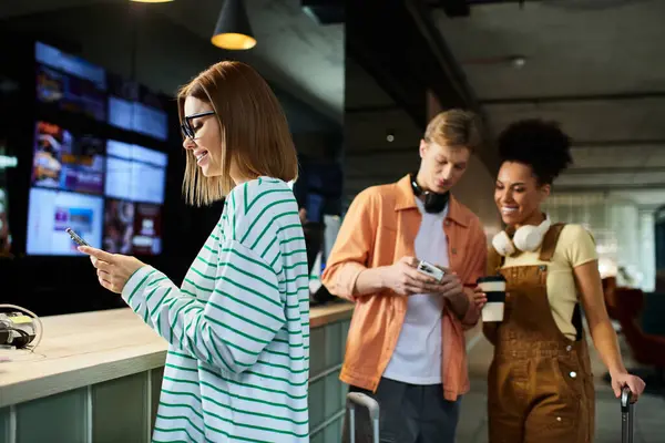 Three colleagues engage in cheerful conversation while checking in at a trendy hotel lobby. — Stock Photo