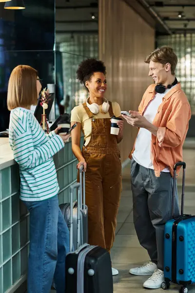 Trois collègues discutent chaleureusement à la réception de l'hôtel, profitant de leur temps ensemble. — Photo de stock
