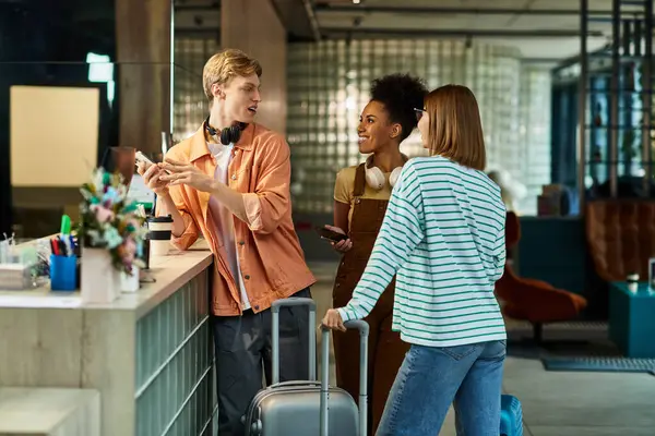 Three colleagues interact at a hotel reception while preparing for their business activities. — Stock Photo