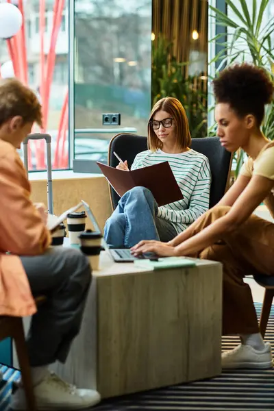 Three colleagues engage in planning and discussion in a stylish hotel lounge setting. — Stock Photo