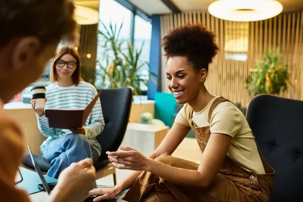 Three colleagues collaborate in a chic hotel lobby, exchanging ideas and enjoying company. — Stock Photo