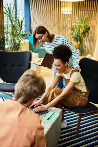 Team members engage in a productive discussion while working on a laptop in a hotel setting. — Fotografia de Stock