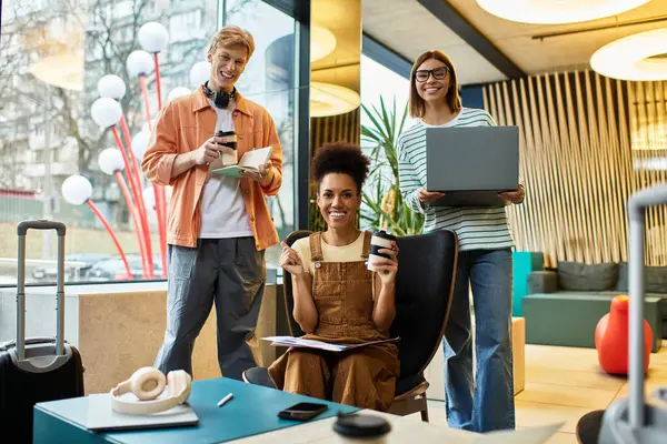 Un gruppo di colleghi si riunisce nella hall di un hotel, condividendo idee e caffè mentre collabora. — Foto stock