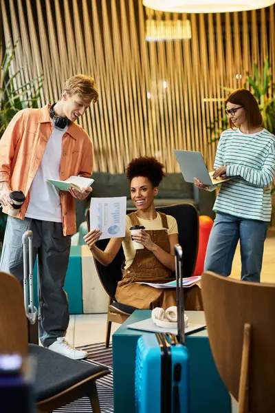 Three colleagues engage in a productive discussion at a hotel lounge, sharing ideas and materials. — Stock Photo