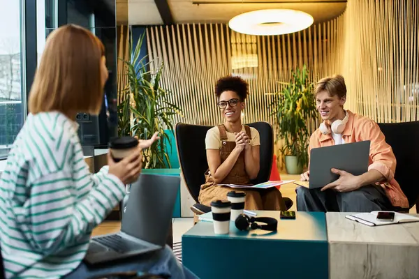 I colleghi condividono idee e risate nella lounge dell'hotel mentre lavorano a un progetto collaborativo — Foto stock