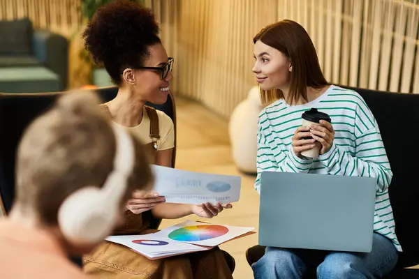 Two colleagues animatedly share ideas while one enjoys a drink. — Stock Photo