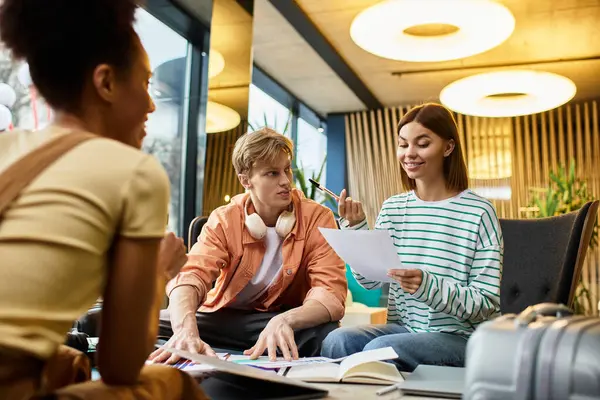 Three colleagues engage in a lively discussion while reviewing documents at a hotel lounge. — Stock Photo