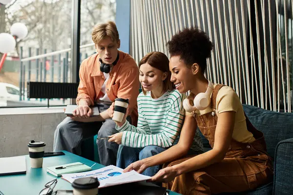 Three colleagues discuss their work while enjoying coffee in a stylish hotel lounge. — Stock Photo
