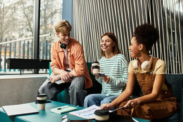 Three colleagues relax and collaborate at a stylish hotel lounge during a team trip. — Stock Photo