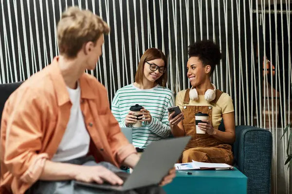 Colleagues relax in a hotel lounge, engaged in conversation while sipping warm drinks. — Stock Photo