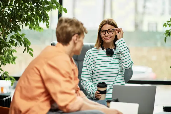 Two colleagues converse in a hotel lounge, discussing work and enjoying coffee together. — Stock Photo