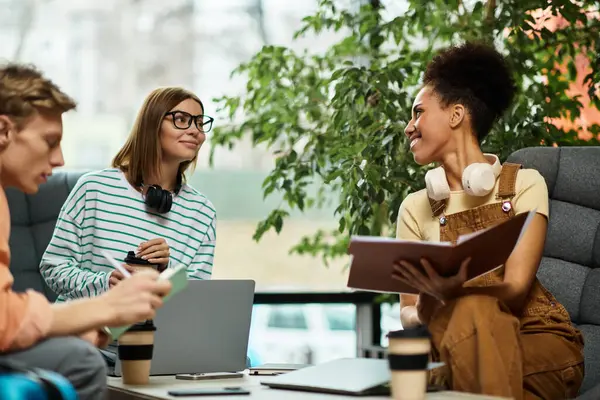 Three colleagues share ideas and relax in a hotel lounge while working together. — Stock Photo