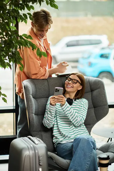 Two colleagues share a fun moment in the hotel lobby before their business trip. — Stock Photo