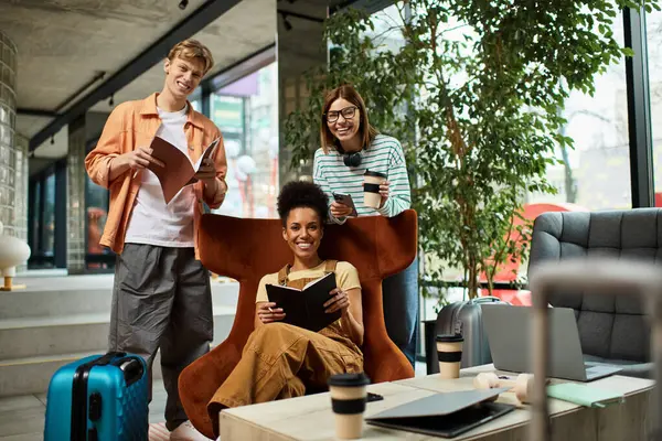 Tres colegas socializan en el vestíbulo de un hotel, compartiendo ideas y risas mientras se relajan. - foto de stock