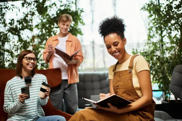 Three colleagues engage in discussion while working on notes in a cozy hotel lounge area. — Stock Photo