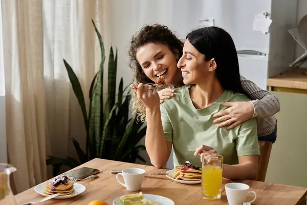 Happy lgbt couple enjoy pancakes together, sharing love and laughter in their cozy home. — Stock Photo