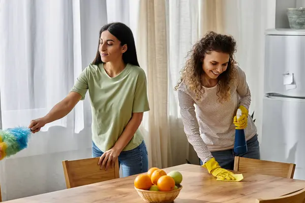 Two cheerful women engage in cleaning their stylish apartment, fostering a loving home. — Stock Photo