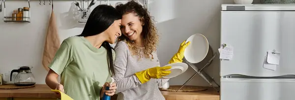 Due donne allegre condividono un momento gioioso nella loro cucina moderna mentre riordinano insieme, striscione — Foto stock