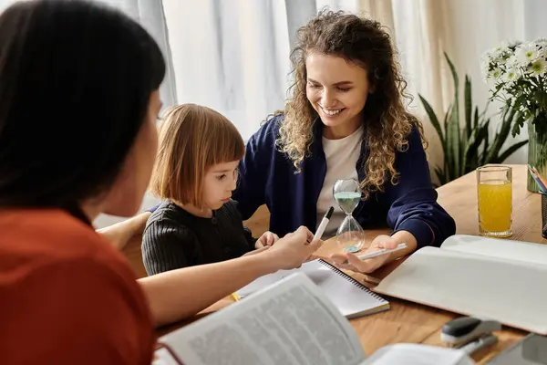 Two women support their daughter in creative learning activities at home, fostering joy. — Stock Photo