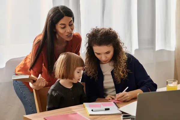 Due donne guidano la loro figlia in un'attività divertente ed educativa in un appartamento elegante. — Foto stock