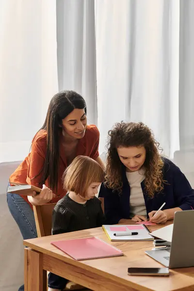 Due mamme amorevoli sostengono la loro figlia in progetti artistici godendo di tempo di qualità insieme. — Foto stock
