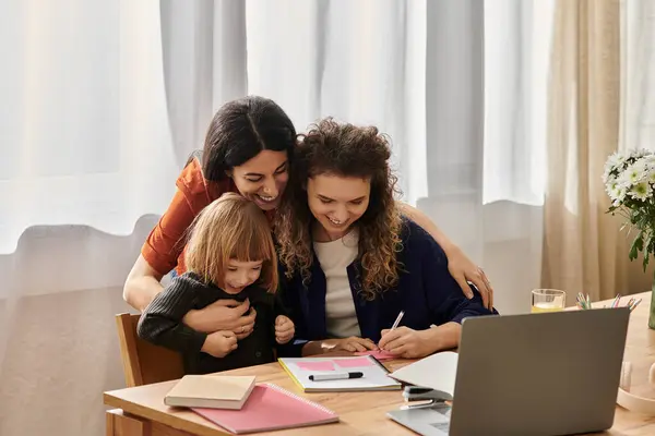 Due donne condividono un momento caldo con la figlia mentre si impegnano in attività creative insieme. — Foto stock