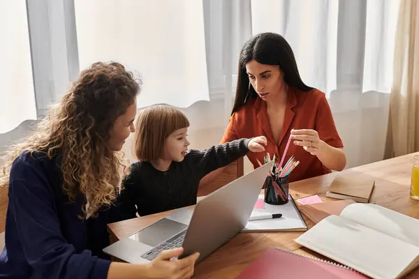 Two women engage with their daughter, fostering creativity at their stylish apartment. — Stock Photo
