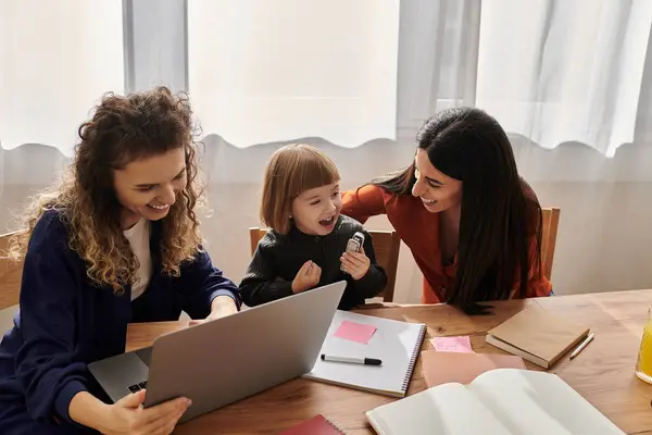 Due donne condividono un momento gioioso con la figlia nel loro accogliente e moderno spazio abitativo. — Foto stock