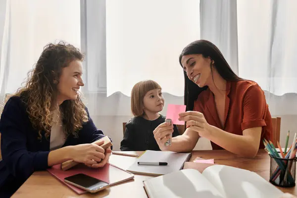 Due donne godono di momenti giocosi con la figlia, condividendo sorrisi e creatività a casa. — Foto stock