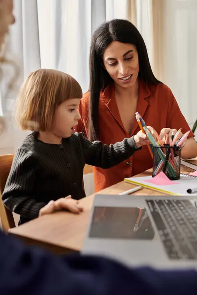 In a stylish apartment, two women help their daughter explore her creativity through art activities. — Stock Photo