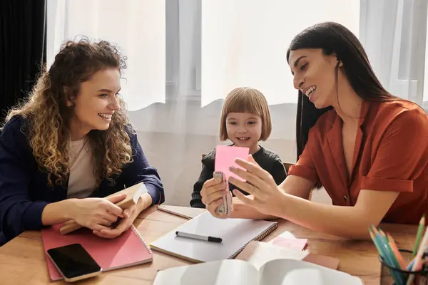 Due donne amorevoli condividono momenti gioiosi con la figlia in uno spazio di vita elegante. — Foto stock