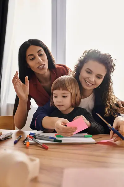 Two women joyfully assist their daughter with creative activities in their stylish apartment. — Stock Photo