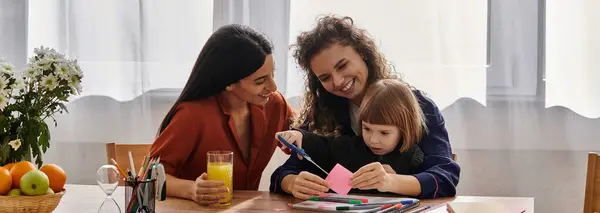 In a cozy, modern apartment, two women share joyful moments while crafting with their daughter, banner — Stock Photo