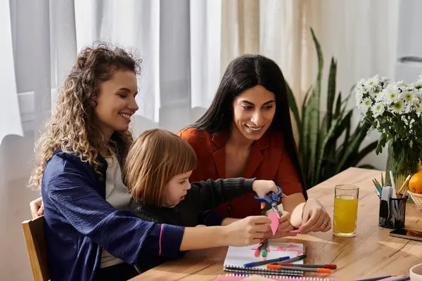 Zwei Frauen basteln freudig mit ihrer kleinen Tochter in einer schicken Wohnung. — Stockfoto