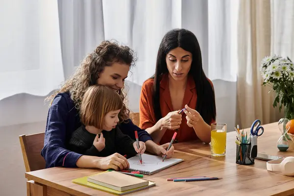 Due donne e la loro figlia godono di un momento creativo a casa, circondati da forniture d'arte. — Foto stock