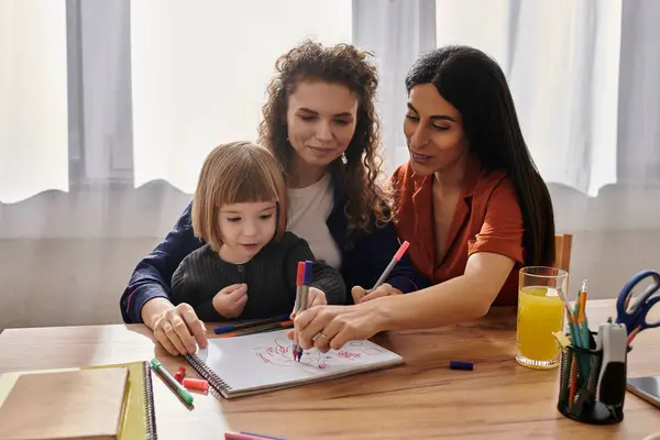 Due donne si impegnano in una divertente attività artistica con la loro giovane figlia, condividendo risate e creatività.. — Foto stock