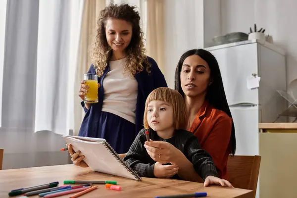 In un appartamento moderno, due donne sostengono la figlia mentre esplora la sua creatività con i colori. — Foto stock