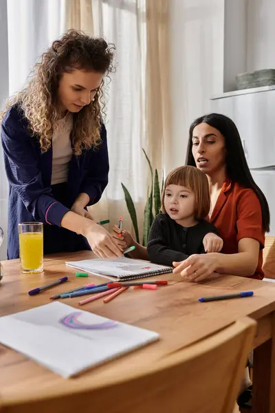 Deux parents aimants engagent leur fille dans une activité de dessin amusant à la maison. — Photo de stock