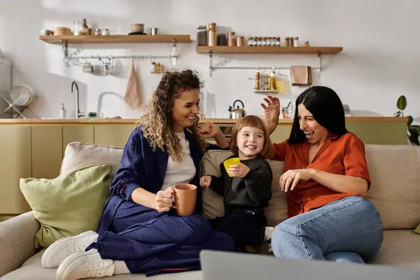 Two women enjoy a joyful moment with their daughter in a stylish modern apartment. — Stock Photo