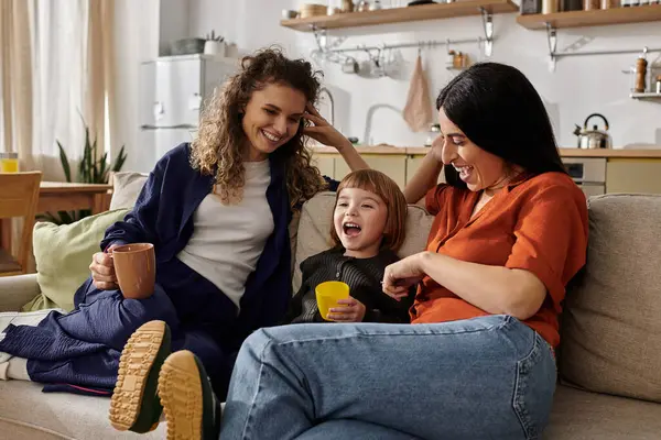 Zwei Frauen verbringen einen gemütlichen Moment mit ihrer Tochter in einer stilvollen Wohnung und genießen das Leben. — Stockfoto