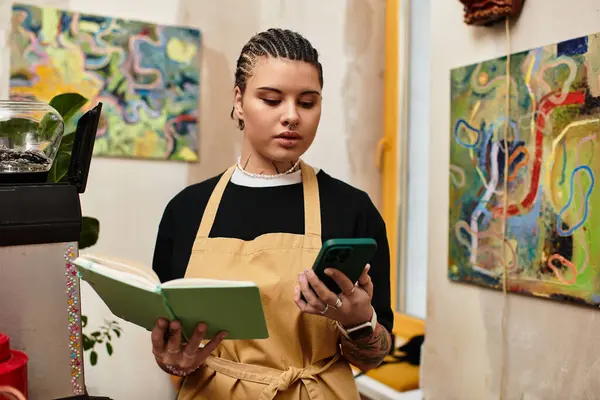 In a cozy cafe, a young woman juggles tasks, engaged in a digital chat while checking notes. — Stock Photo