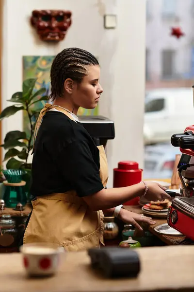 Focused barista skillfully prepares a delicious cup of coffee in a cozy cafe atmosphere. — Stock Photo