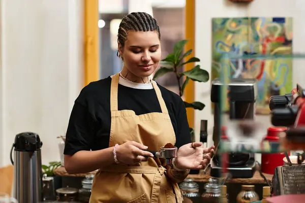 Young barista skillfully prepares coffee, enjoying the vibrant atmosphere of the cafe. — Stock Photo