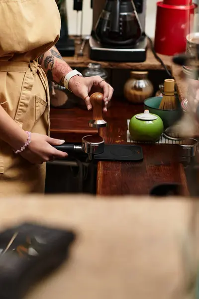 A young woman skillfully prepares coffee, showcasing her dedication in a charming cafe setting. — Stock Photo