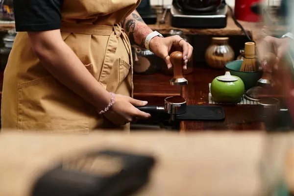 A young woman expertly uses a tamper to prepare espresso, showcasing her barista skills in the cafe. — Stock Photo