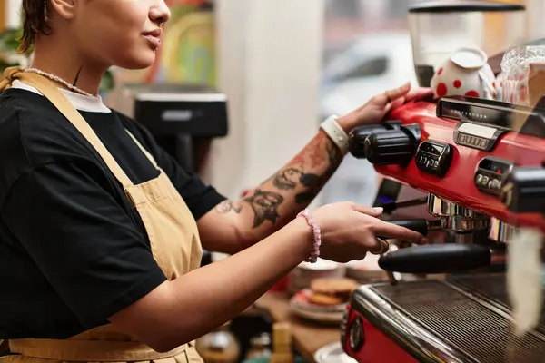 A beautiful young woman expertly operates an espresso machine in a lively cafe atmosphere. — Stock Photo
